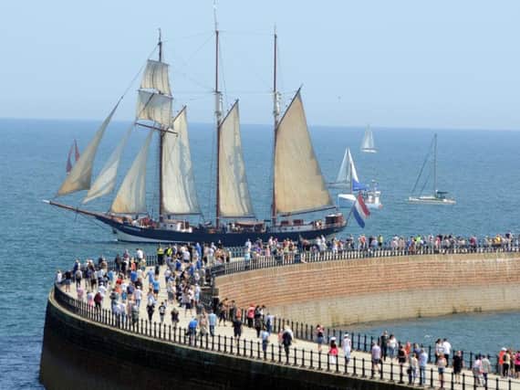People gather on Roker Pier to watch the Tall Ships parade of sail as they prepare to leave Sunderland.