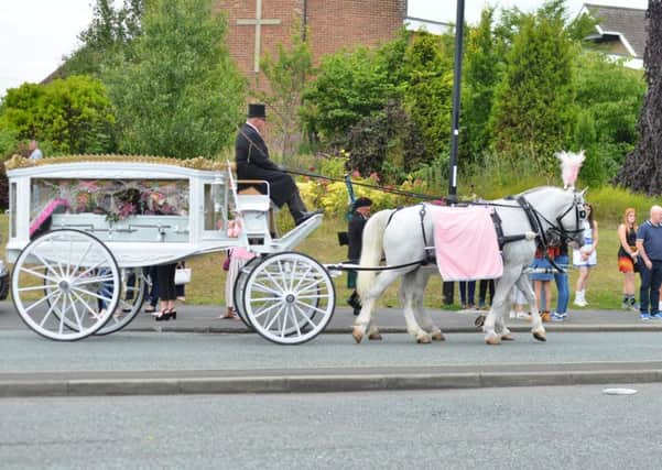 A horse-drawn carriage arrives carrying Josie King's coffin.