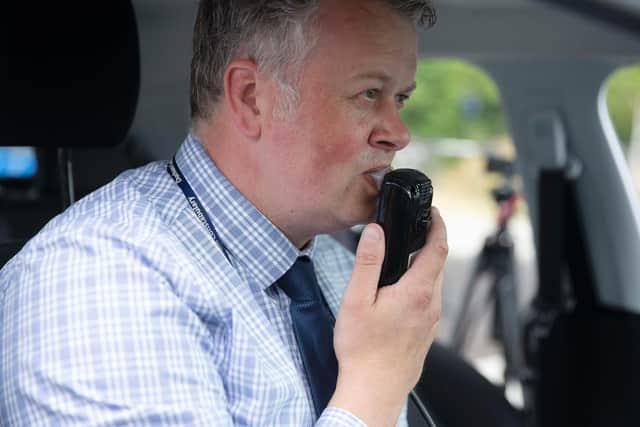 Detective Inspector Andy Crowe demonstrates the in-car alcohol interlock device, which immobilises a vehicle if the driver is over the limit. Pic: Owen Humphreys/PA.
