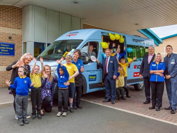Headteacher Lesley Mavin and Miles Baron, chief executive of the Bingo Association, with staff and pupils by the new minibus.