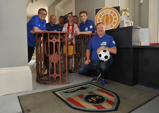 Sunderland Fans Museum's Michael Ganley, and team members with the original Roker Park turnstile.