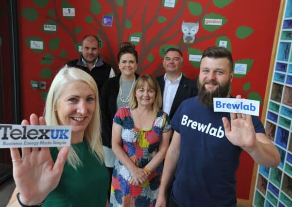 Telexuk's Gemma Massey and Brewlab's Richard Hunt add their businesses to the tree at Grace House.