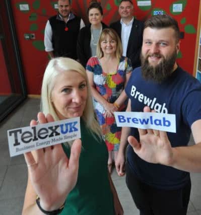 Telexuk's Gemma Massey and Brewlab's Richard Hunt add their businesses to the tree at Grace House.