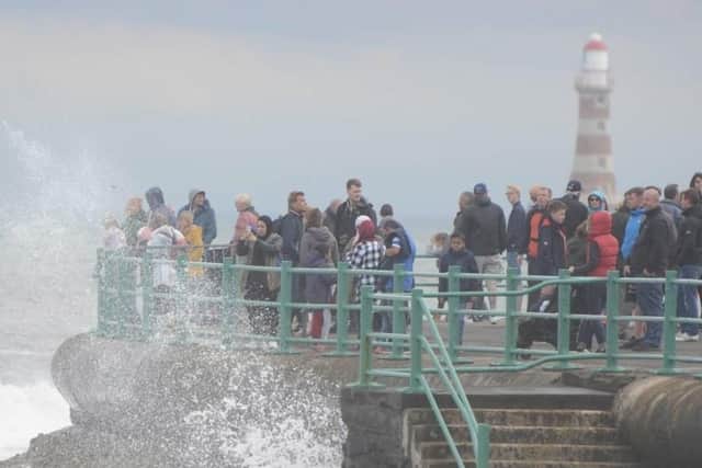 Waves smash against the sea wall as crowds watch the final day of the 2018 Sunderland Airshow.