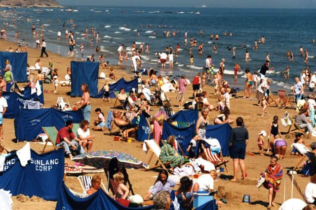 Crowds of people enjoy the sunny weather on Seaburn Beach in August 1995.