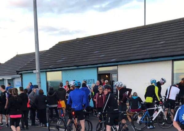 Cyclists gather outside the cafe for a ride.