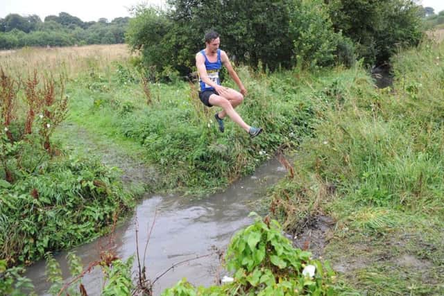 Birltey athlete Adrian Bailes clears the famous Gilley Law stream.