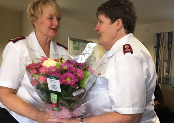 Major Gillian Coates (left) presents Major Mary Johnson with her retirement gifts.