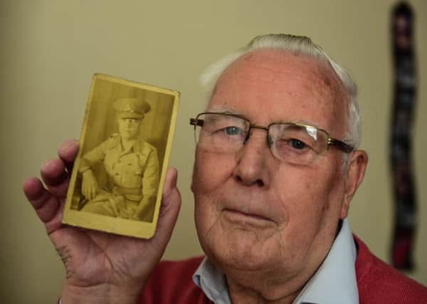 Francis Dilston with a photograph of his father Ralph.