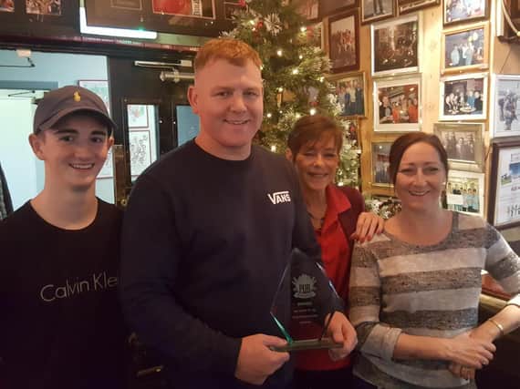 Manager at The Dolphin, holding award, Carl Donkin with the Echo's Pub of the Year honour alongside fellow staff.