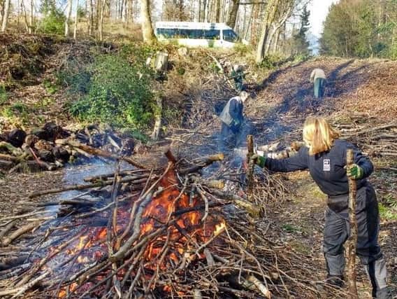 Durham Wildlife Trust volunteers using fire to dispose of natural waste materials in an eco-friendly way.