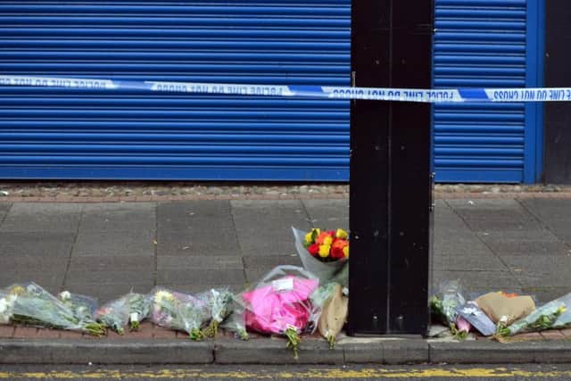 Floral tributes to Joan Hoggett outside the shop where she was murdered.