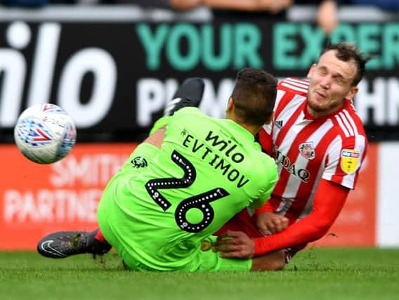 Sunderland striker Charlie Wyke collides with Dimitar Evtimov.