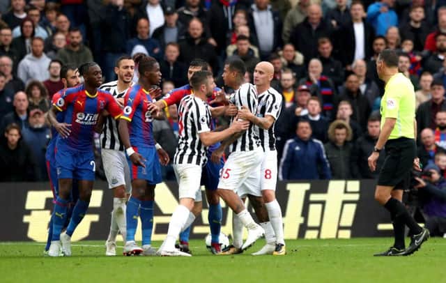 Wilfried Zaha (centre) clashes with Kenedy in a rare moment of excitement at Selhurst Park.