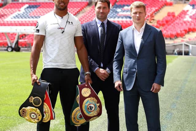 Eddie Hearn is flanked by Anthony Joshua (left) and Alexander Povetkin (right).