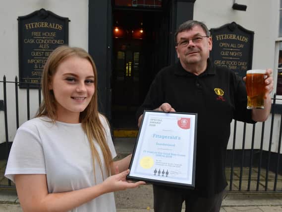 The chair of Sunderland and South Tyneside Camra, Michael Wynne, presents the certificate to staff member Beth Williams.