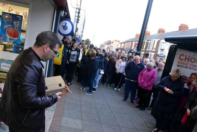 The Rev Gareth Phillips addresses the crowd outside the One Stop store where Joan worked