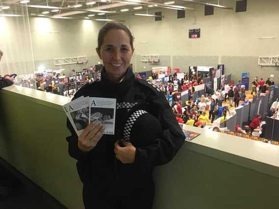 A Northumbria Police officer with the greetings cards at Sunderland University's freshers' fayre.