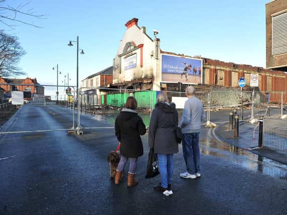 Residents look on at the damage caused to the former bingo hall and auction house.