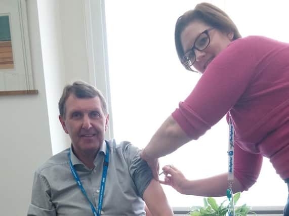Ken Bremner, Chief Executive of South Tyneside and City Hospitals Sunderland NHS Foundation Trusts, is given his flu vaccination by Occupational Health & Wellbeing Manager Anna Porter.
