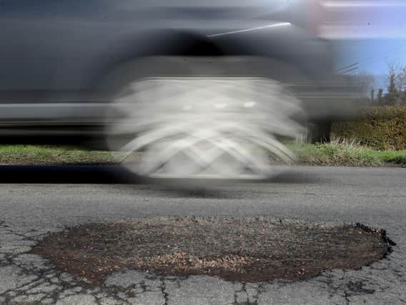 A car driving past a pothole. RAC research has found that drivers are more than twice as likely to break down due to hitting a pothole than 12 years ago. Picture by Gareth Fuller/PA Wire