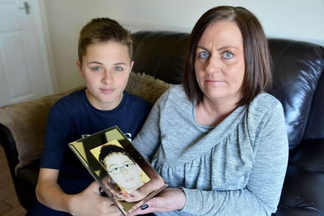 Janine Dodd (43) with her son Mackenzie Stores (13) holding a photograph of her late son Dean Pike (11).