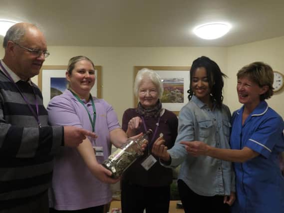 Volunteer Ian Watt and his granddaughter, Chika Izoura, (second left) hand over his latest 5ps to St Cuthbert's Hospice.