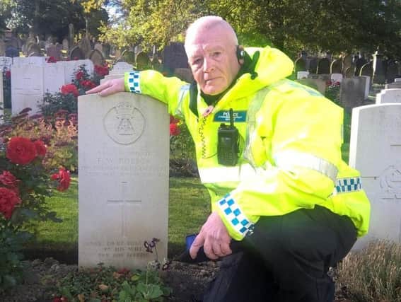 PCSO Jim Tuckwell next to the grave of Sunderland soldier, Frederick Whelens Robson, who served with 14th DLI in Bishopwearmouth Cemetery, Sunderland. PTE Robson had been a professional footballer who was capped for Scotland at international level.
