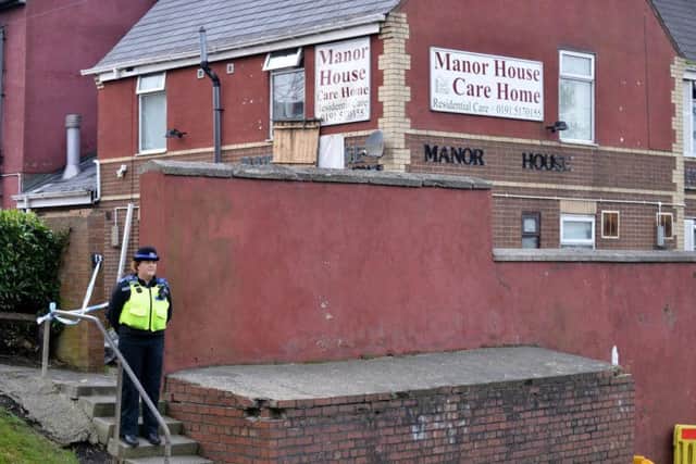 A police officer stands guard outside the former Manor House Care Home in Easington Lane.