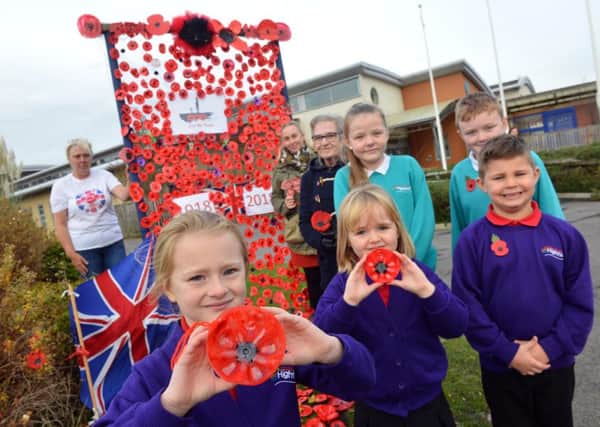 Highfield Academy parents group and pupils unveil the poppy display.