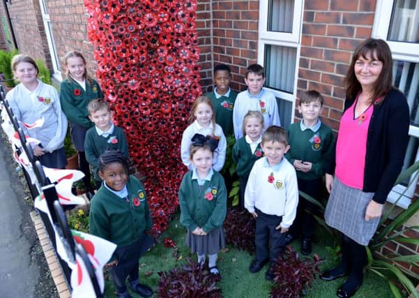St Patrick's RC Primary School  pupils with Deputy Headteacher Jane Mather next to their cascading poppy display.