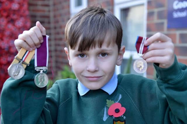 Pupil Ryley McLaughlin with his mum and dad's army medals.