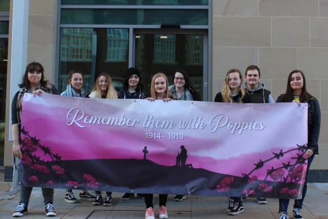 Chantelle Watkins (centre) with art and design students outside the Arts Academy, holding her Riding Mill banner.