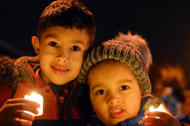 Youngsters light candles at the Christmas lights switch-on