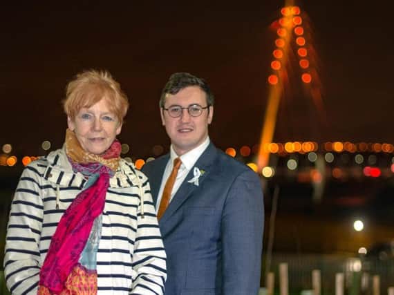 Dame Vera Baird and Coun Michael Mordey in front of the Northern Spire bridge, lit orange to back the UN campaign.