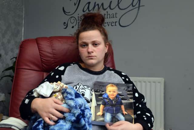 Katrina Farnell holds a picture of her son Sheldon