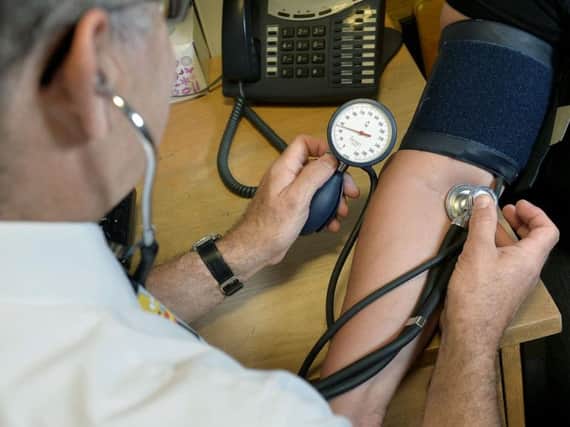 A doctor checks the blood pressure of a patient.