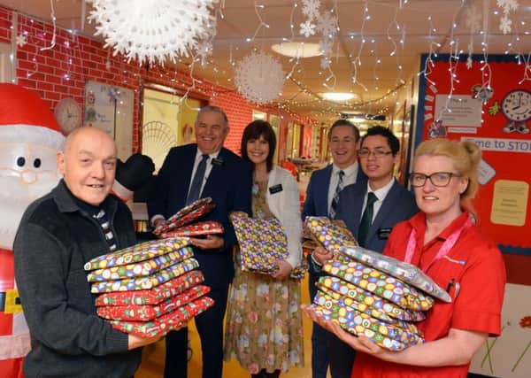 Norman Imms hands over presents with nursery nurse Carol Davison and members of The Church of Jesus Christ of Latter-day Saints.