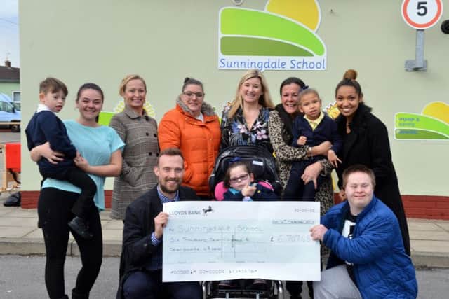 Sunningale School deputy headteacher James Waller receives funds from former pupil Ricky Graham from fundraiser organised by Paula Lay, grandmother of Tiana Johnson, 5.