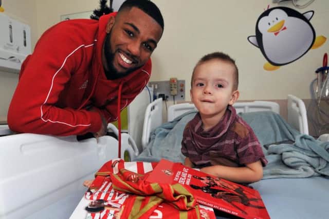 Jerome Sinclair presents Christmas gifts to a young fan.