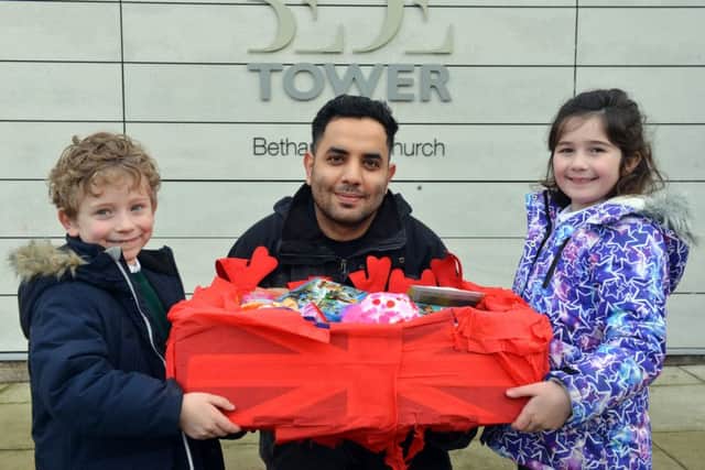 Samuel Errington , five, and Abby Bell, seven, offer  hamper donations to Bede Tower Global Cafe, pictured with refugee Miaad Hajianfar.