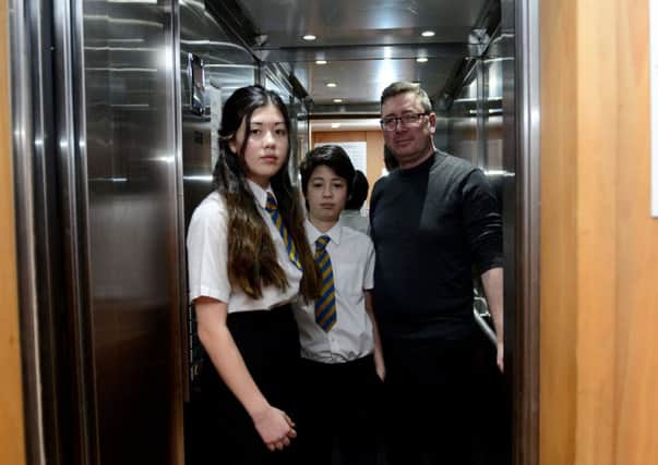Jasmine and Myles Newrick with their dad James in the lift