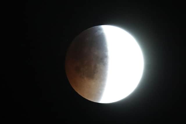 A total lunar eclipse colours the lunar surface a reddish hue at the same time it appears brighter and closer to earth than normal, seeing phenomena known as a blood moon and supermoon combine. Picture: PA.