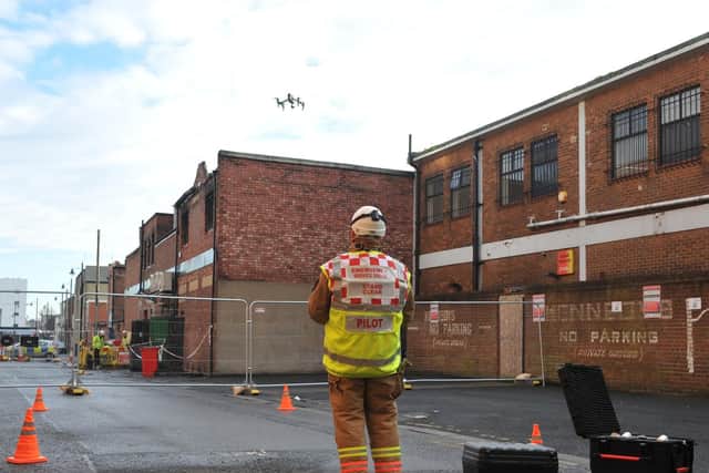 Firefighters use a drone to get an aerial view of damage to the fire-hit building