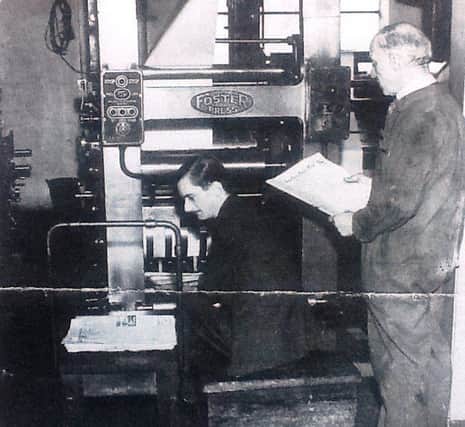 Percy, standing, pictured next to a printing machine.