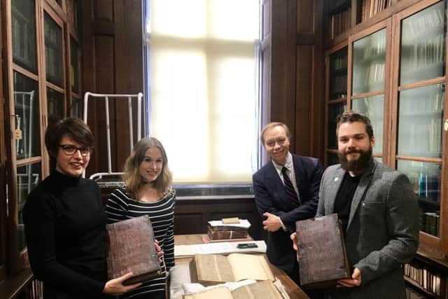 Leah Tether, Laura Chuhan Campbell, Michael Richardson and Benjamin Pohl with a series of 16th-century books in Bristol Central Library's Rare Books Room. A chance discovery has led to the unearthing of fragments of a manuscript from the Middle Ages which tells the story of Merlin the magician.