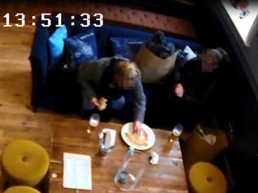 The pair can clearly be seen adding the hair to the pizza.