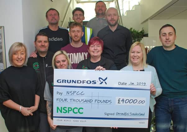 Katy Carmen, front, second right, receives the cheque for £4,000 from members of the Grundfos team, and General Manager Mark Lister, front right
