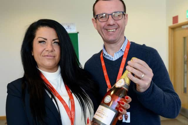 ResQ call centre worker Kathryn Fisher is presented with a gift by Senior team manager Neil Ross.