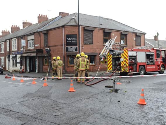 The road is closed off while firefighters tackle the blaze at DACCS salon.